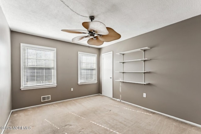 carpeted empty room with a textured ceiling and ceiling fan