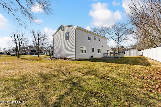 back of house featuring a lawn and a storage unit