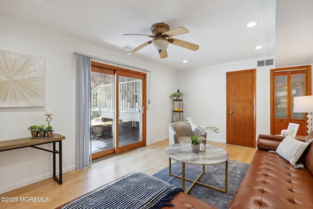 living room with ceiling fan and light hardwood / wood-style flooring