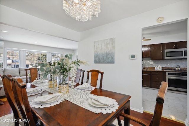 dining space featuring light hardwood / wood-style floors and a notable chandelier