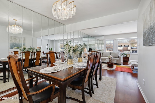 dining room with dark hardwood / wood-style flooring and an inviting chandelier