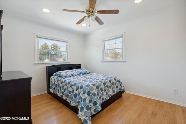 bedroom with crown molding, multiple windows, and light hardwood / wood-style flooring