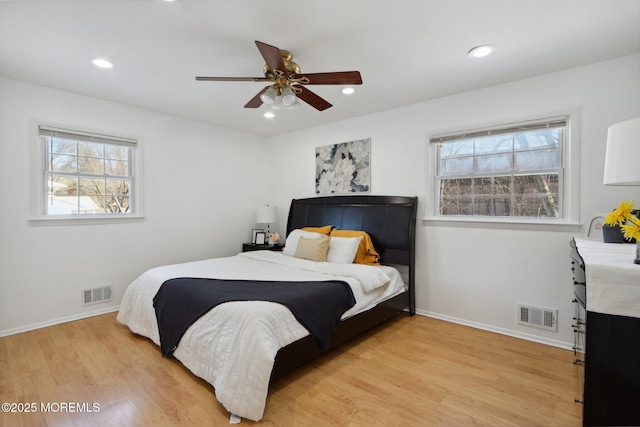 bedroom featuring ceiling fan, multiple windows, and light wood-type flooring