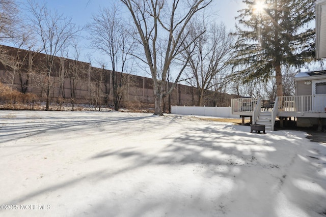 yard covered in snow with a deck