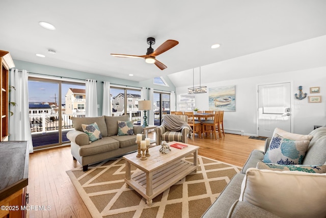 living room with vaulted ceiling, ceiling fan, and light hardwood / wood-style flooring