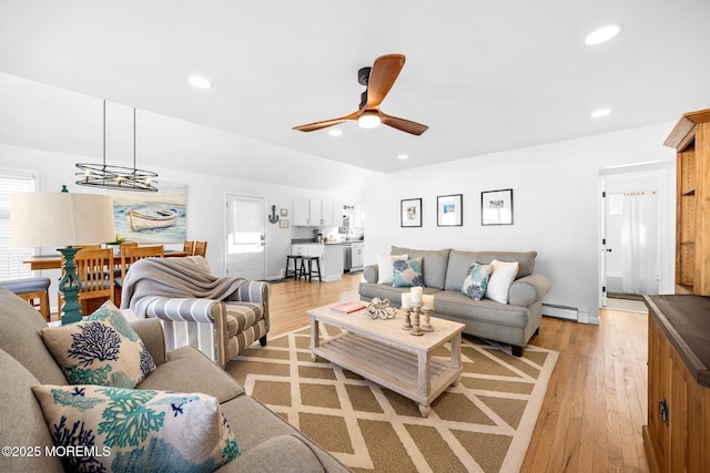 living room featuring ceiling fan and light hardwood / wood-style floors