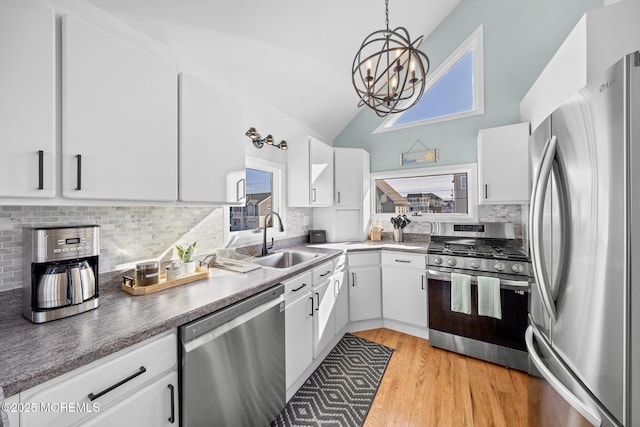 kitchen with white cabinetry, sink, decorative light fixtures, and stainless steel appliances