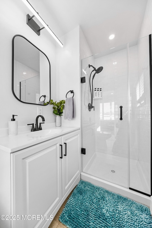 bathroom with vanity and a shower with door