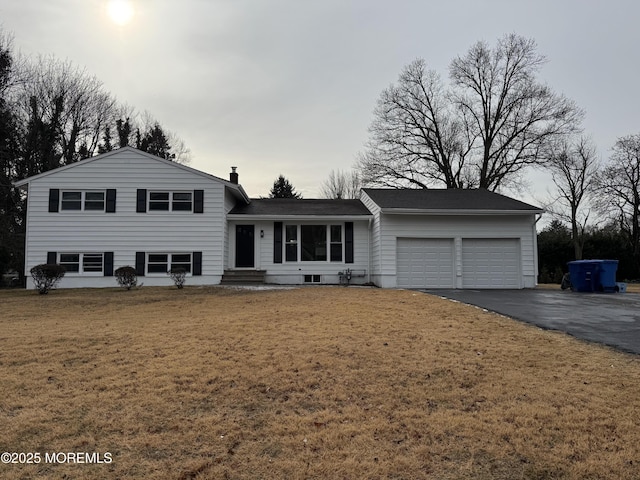 tri-level home with a garage and a front yard