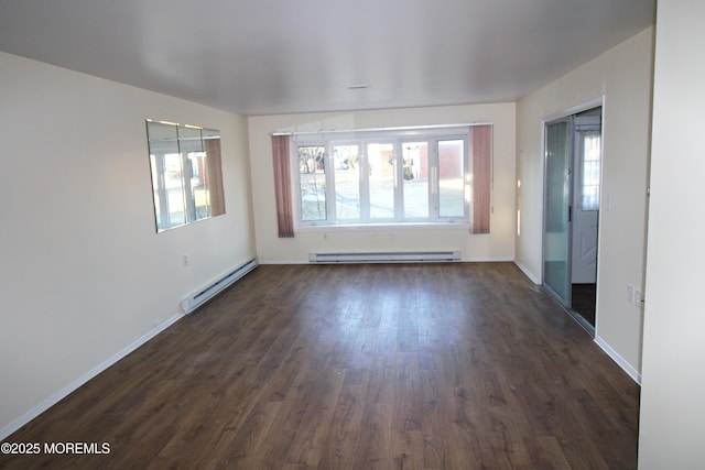 spare room featuring plenty of natural light, dark wood-type flooring, and baseboard heating