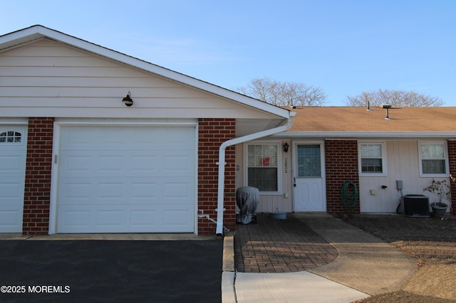 ranch-style home featuring a garage and central AC unit