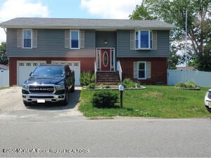 bi-level home with a garage and a front lawn