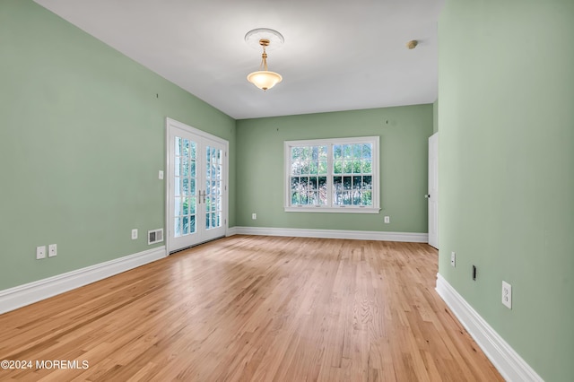 unfurnished room featuring light hardwood / wood-style floors and french doors