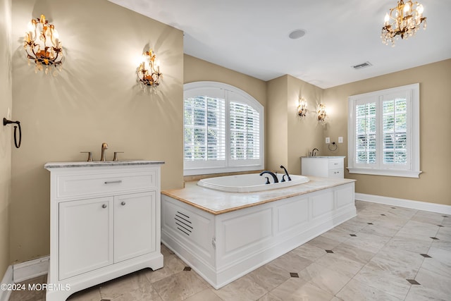 bathroom featuring vanity, a tub to relax in, a healthy amount of sunlight, and an inviting chandelier