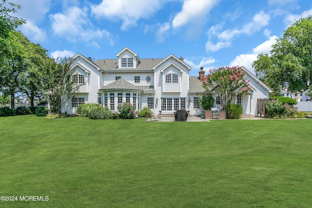 back of house with a patio area and a lawn