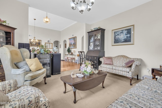 living room with light carpet, baseboards, arched walkways, and a notable chandelier