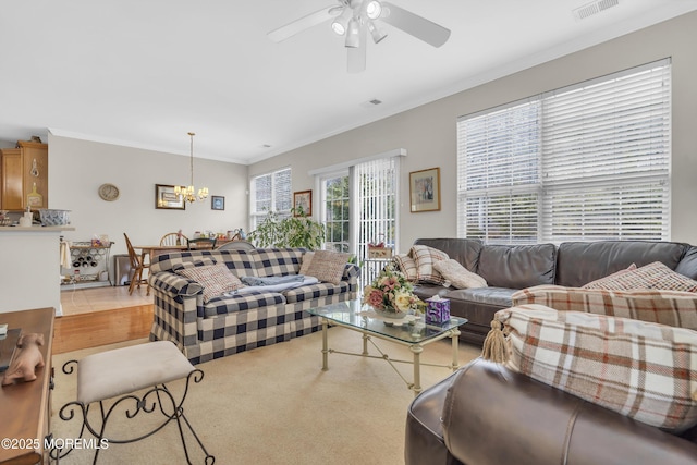 living area with visible vents, crown molding, and ceiling fan with notable chandelier