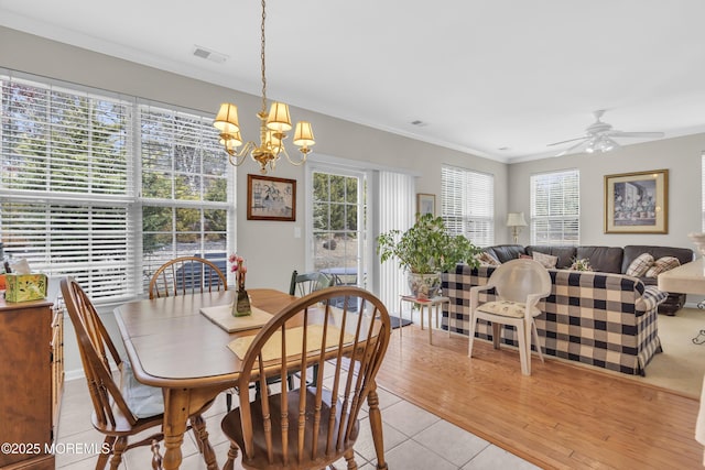 dining area with ceiling fan with notable chandelier, ornamental molding, light tile patterned flooring, and visible vents