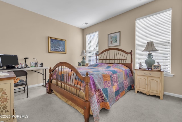 bedroom featuring baseboards, visible vents, and light colored carpet