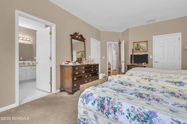 bedroom with visible vents, light carpet, a sink, ensuite bath, and baseboards