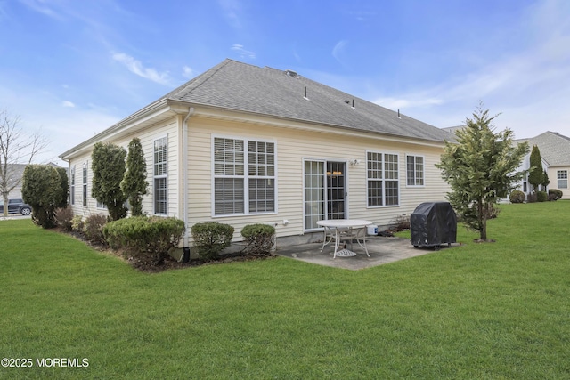 rear view of house with a yard, a shingled roof, and a patio