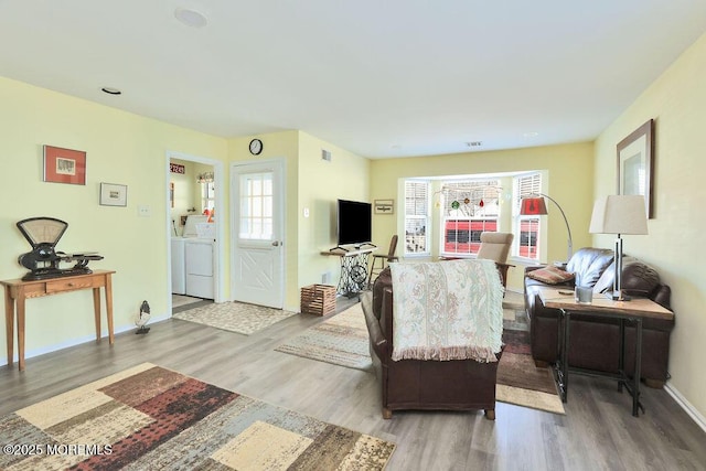 living room with hardwood / wood-style floors and washing machine and clothes dryer