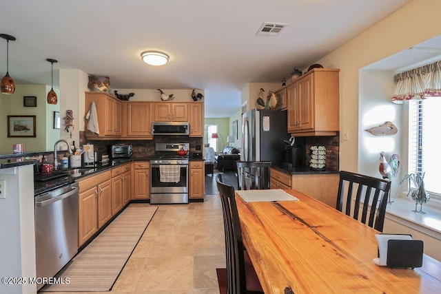 kitchen featuring butcher block counters, sink, decorative light fixtures, stainless steel appliances, and decorative backsplash