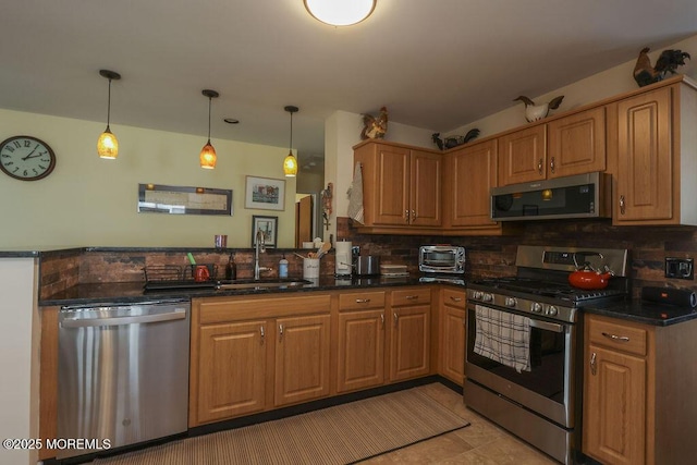 kitchen featuring appliances with stainless steel finishes, pendant lighting, tasteful backsplash, sink, and kitchen peninsula