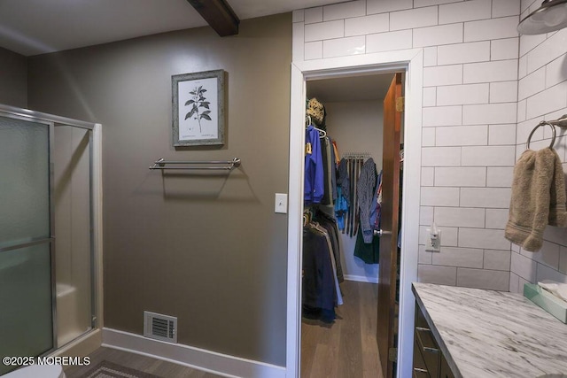 bathroom with vanity, an enclosed shower, and wood-type flooring