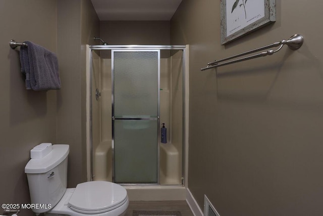 bathroom featuring an enclosed shower and toilet