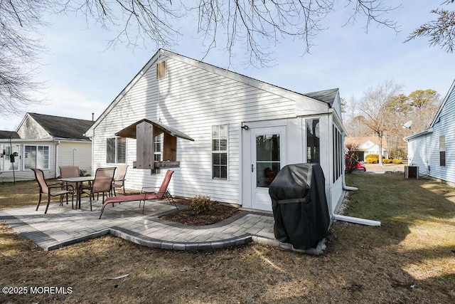 rear view of house featuring a lawn, central AC, and a patio area