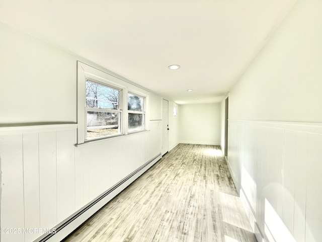 hallway with a baseboard heating unit and light wood-type flooring