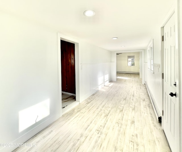 hall featuring light hardwood / wood-style floors and a baseboard heating unit