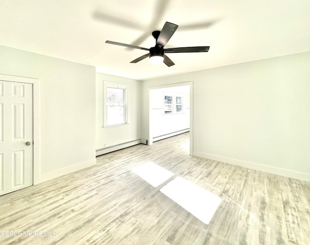 empty room with ceiling fan, a baseboard heating unit, and light hardwood / wood-style floors