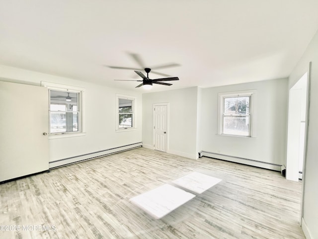 empty room with ceiling fan, light hardwood / wood-style flooring, and a baseboard heating unit