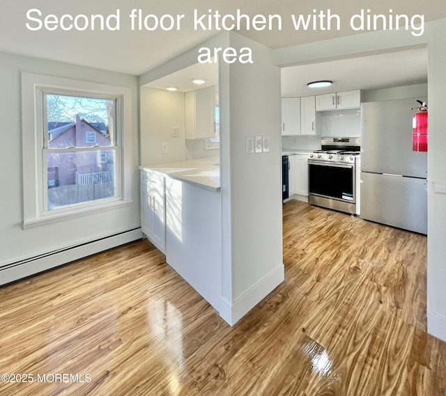 kitchen featuring appliances with stainless steel finishes, a baseboard heating unit, white cabinets, and light hardwood / wood-style flooring