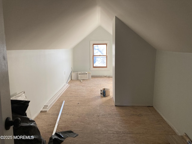 additional living space with lofted ceiling and a wall mounted air conditioner