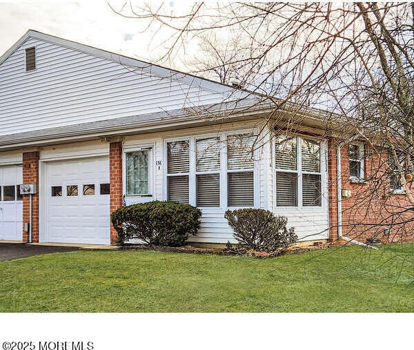 view of front of property with a garage and a front lawn