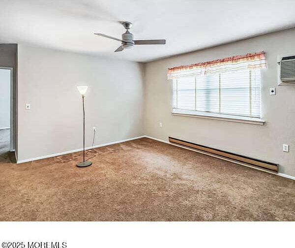 carpeted spare room featuring ceiling fan, a baseboard radiator, and an AC wall unit