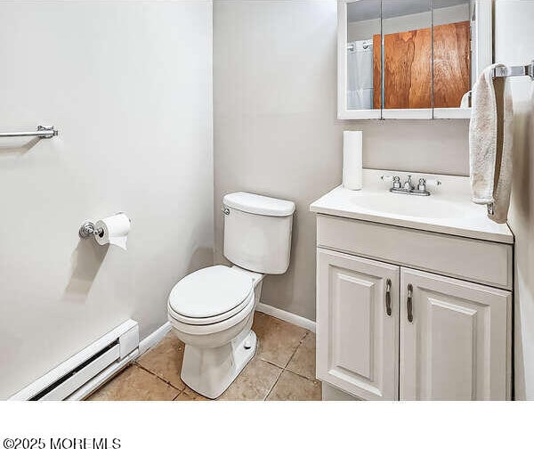 bathroom with tile patterned flooring, a baseboard radiator, vanity, and toilet