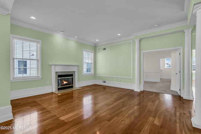 unfurnished living room with ornamental molding, a high end fireplace, decorative columns, and hardwood / wood-style floors