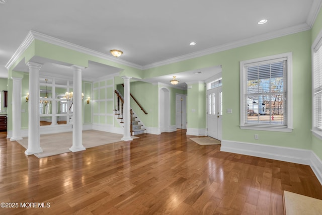 entrance foyer featuring hardwood / wood-style flooring, crown molding, and ornate columns