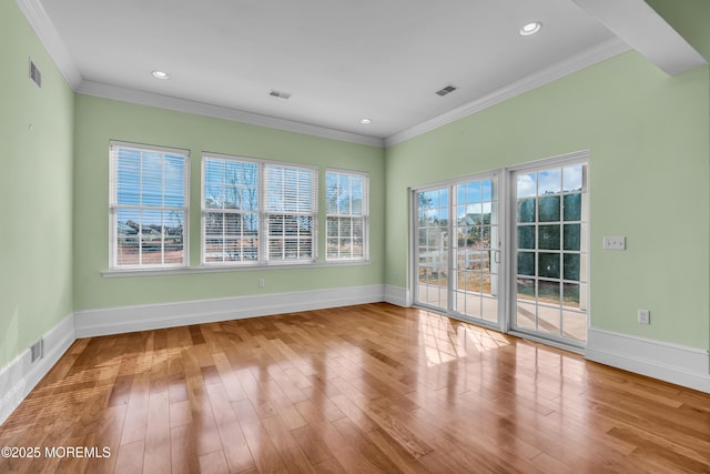 empty room featuring light hardwood / wood-style flooring and ornamental molding