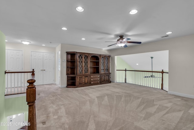 spare room featuring light colored carpet and ceiling fan