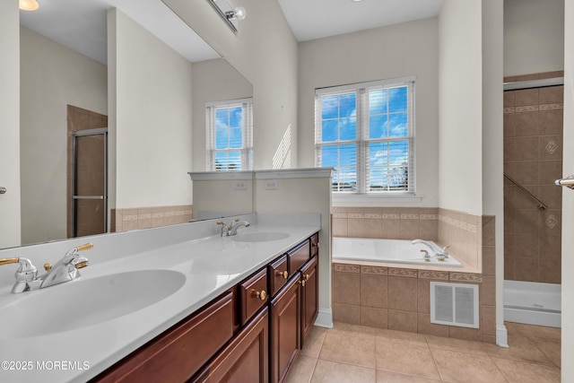 bathroom featuring tile patterned flooring, a wealth of natural light, and independent shower and bath