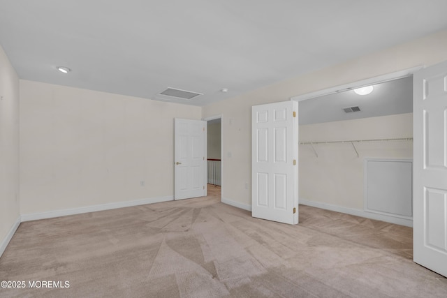 unfurnished bedroom featuring light carpet and a closet