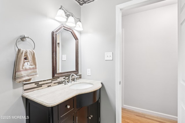 bathroom with hardwood / wood-style flooring, vanity, and backsplash