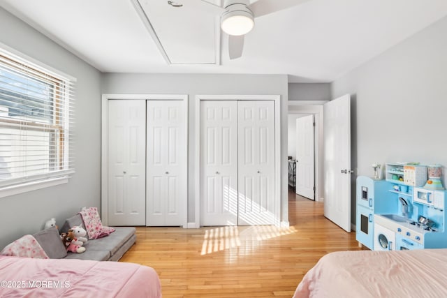 bedroom with multiple closets, ceiling fan, and hardwood / wood-style flooring