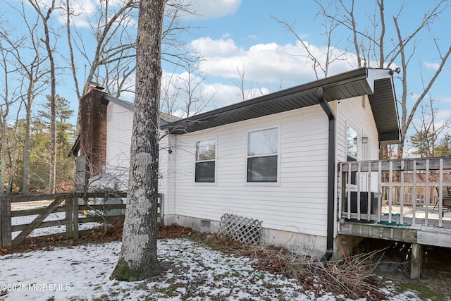 view of snowy exterior with a wooden deck