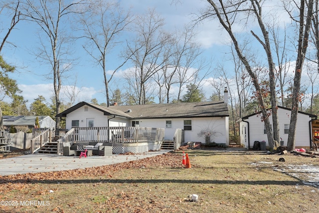 rear view of property featuring a wooden deck, a yard, and a patio area